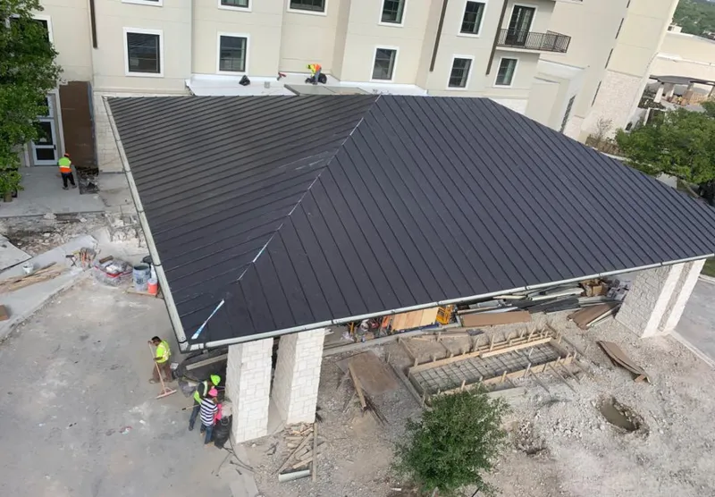 Metal roofing installation team working on a commercial building in Augusta